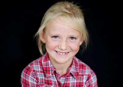 Ania Chandra School photographer in REading , portrait of a girl smiling on a black background
