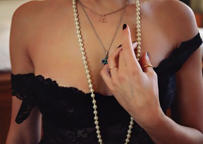 Boudoir photo by ania chandra in Reading - women is touching her perl neckless and you can not see her face - beautiful artistic photo